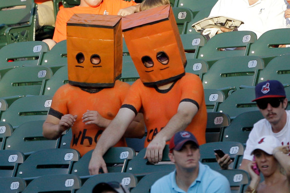 two fans in stands wearing black and orange bags over heads