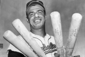 old black and white photo of orioles player holding four bats