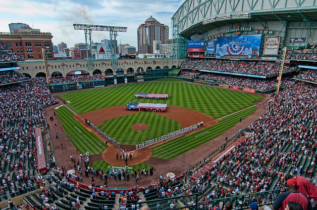 view of entire stadium with people holding flags and players lined up before game