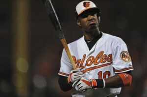 orioles player frowning after hitting baseball