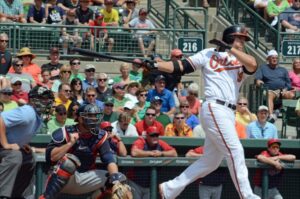 player chris davis after hitting baseball with crowd in back