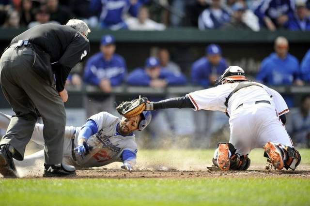 dodger player sliding into home plate with catchers arm and glove out