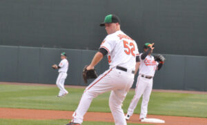 orioles player johnson about to throw pitch with team members in background