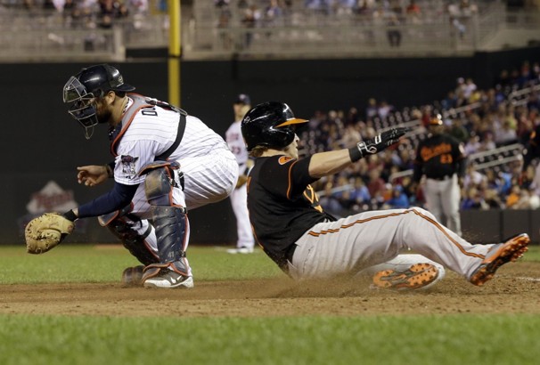 orioles player sliding into home plate with catcher