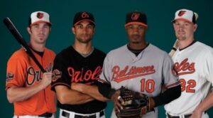 four orioles players lined up in different colored uniforms