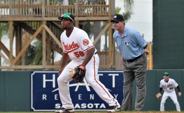 orioles player waiting for ball with other player and ref in background