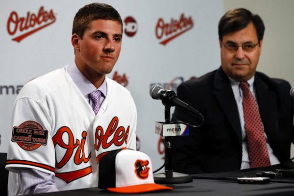 orioles player during press conference up to microphone with guy in suit next to him