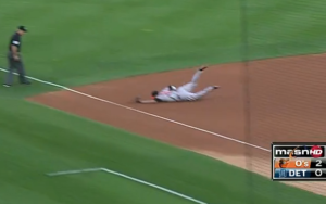 orioles player on ground from diving to catch ball