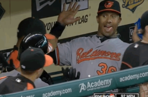 orioles player in dugout holding hands up with mouth open