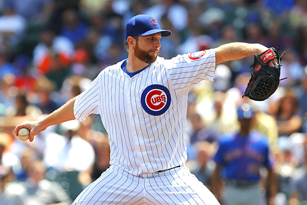 cubs pitcher with glove out and arm back before throwing ball