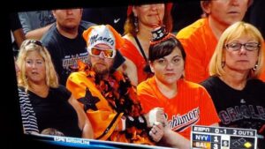 guy in orioles stands wearing orange macho costume and sunglasses