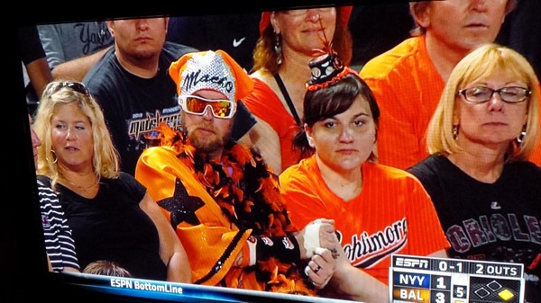 guy in orioles stands wearing orange macho costume and sunglasses