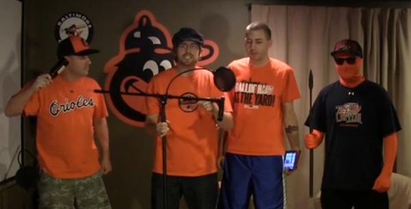 four guys in a room wearing orioles shirts doing radio show