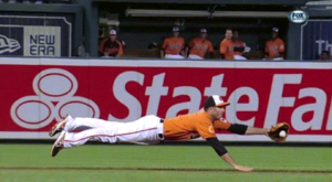 orioles player catching ball while diving on field