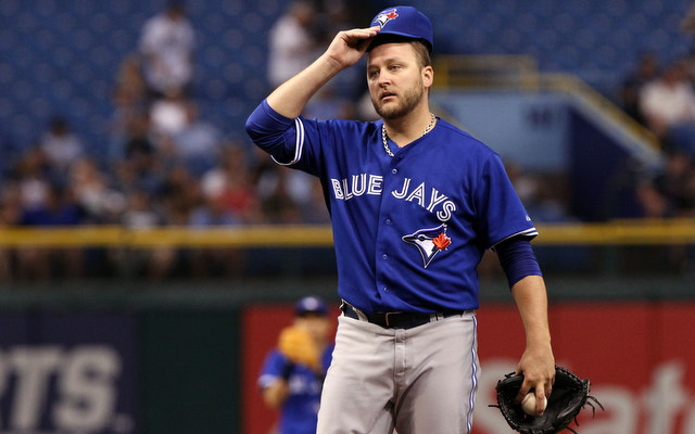 pitcher for toronto blue jays holding hat off head looking frustrated