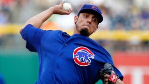 cubs pitcher with arm back clenching lips before throwing pitch