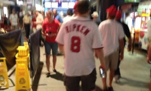 guy walking through crowd wearing cal ripken jersey