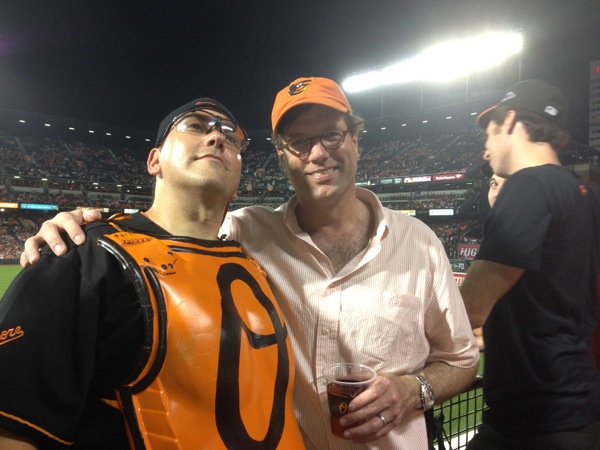 orioles fans standing next to another guy with arm around him