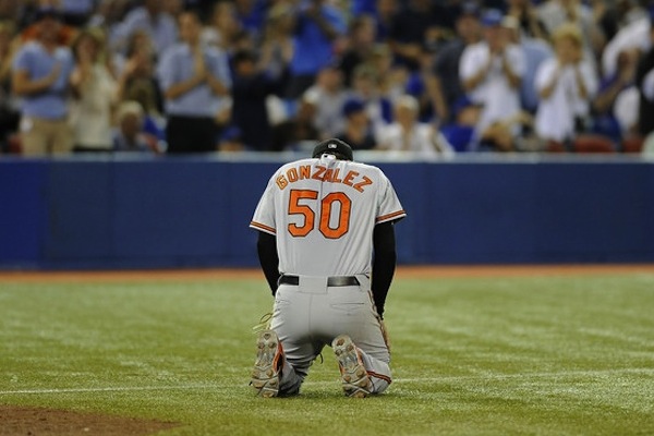 miguel gonzalez kneeling on baseball field