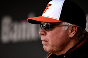 buck showalter staring off into distance with hat and sunglasses on