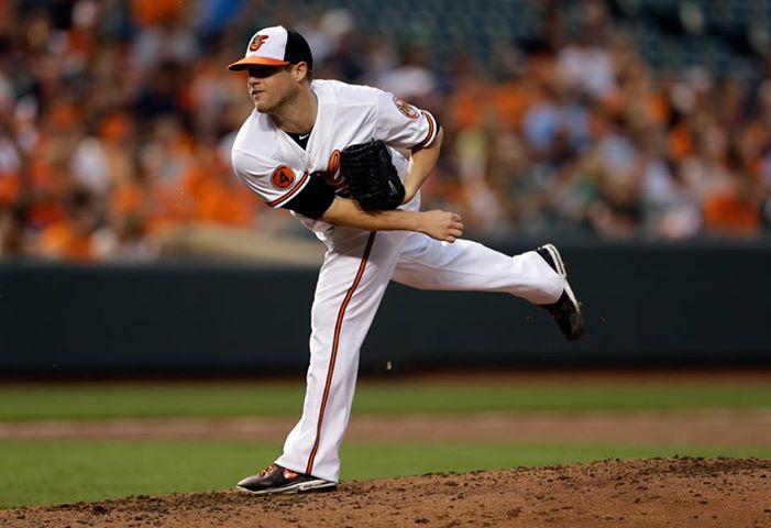 orioles pitcher with leg extended holding glove after throwing pitch