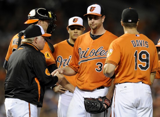 orioles player shaking managers hand while other team members are standing around