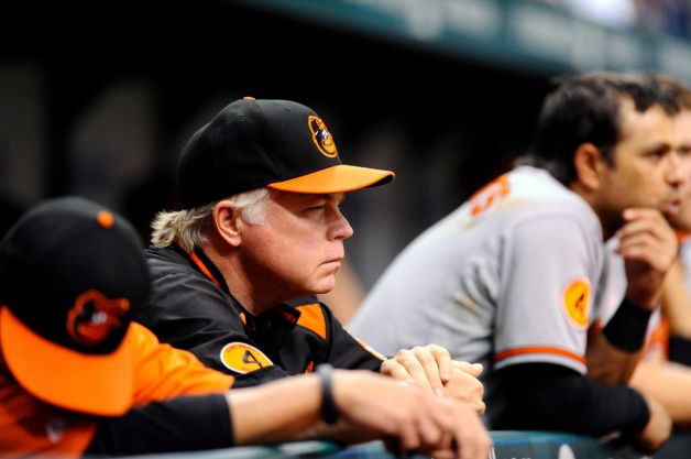 buck showalter leaning on fence frowning looking into distance