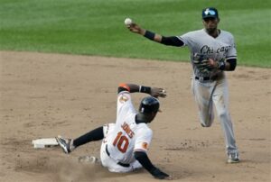 chicago white sox player about to catch ball as orioles is sliding into base