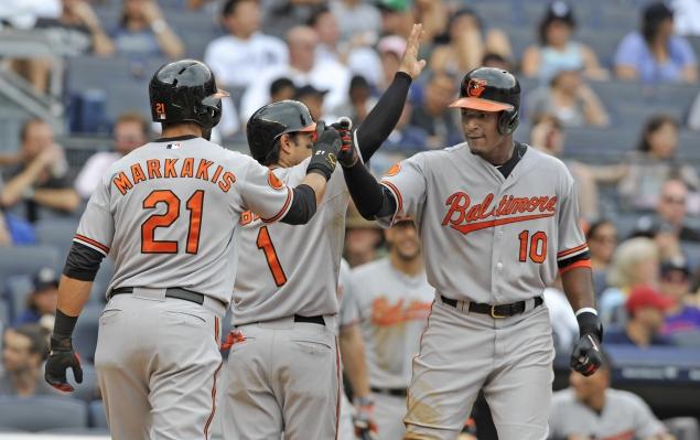 two orioles player bumping fists while third has arm up