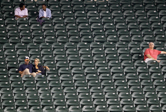 rows of empty seats in stadium with only 5 people