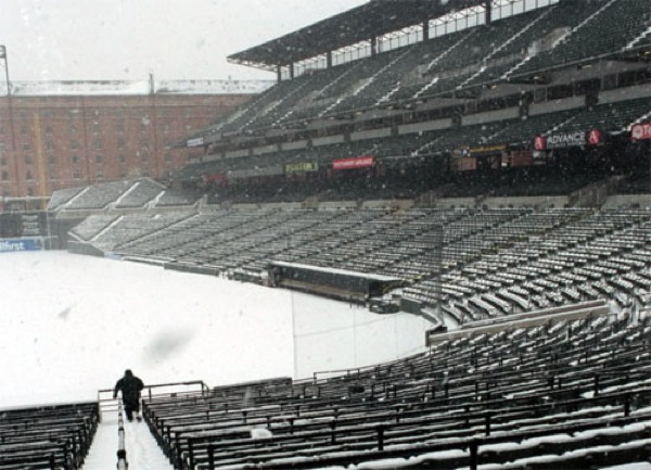 snow covered seats in stadium with man walking down steps