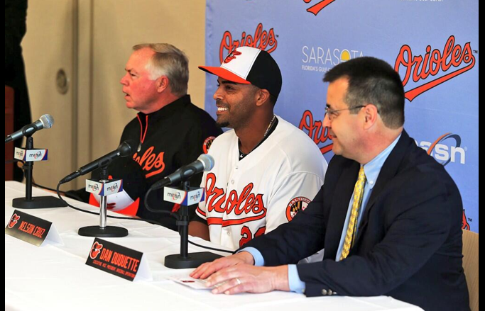 orioles manager player and man in suit sitting at press conference table