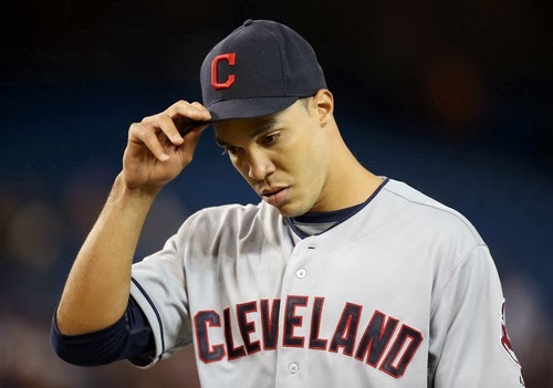 baseball player looking down readjusting hat