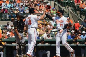 two orioles baseball players giving each other high five