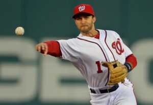 ball player looking directly at baseball after throwing pitch