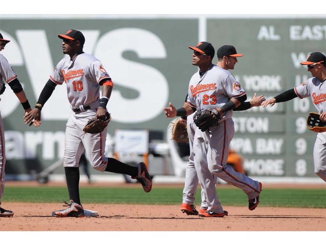 orioles players going by each other slapping hands