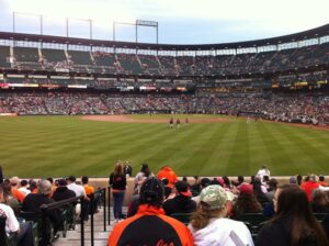 fans in stands at camden yards with view of game in distance