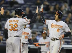 two baltimore orioles baseball players giving high five