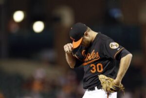 orioles player tillman holding hat brim looking down