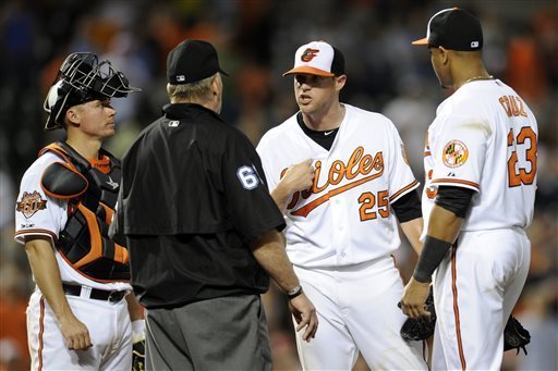 orioles player in referee's face with catcher and other player