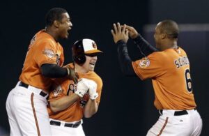three orioles players jumping up with mouths open excited