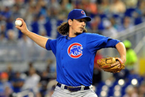 pitcher for chicago cubs with arm back holding baseball before pitch