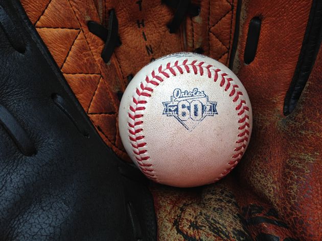 60 years baseball for orioles sitting in glove
