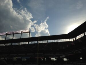 dark upper view of seating at camden yards with clouds and sun