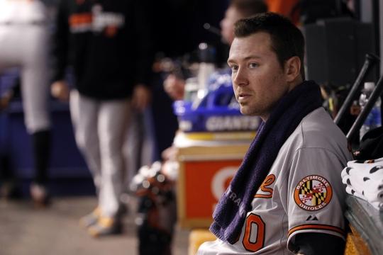 orioles player sitting in dugout with towel around neck
