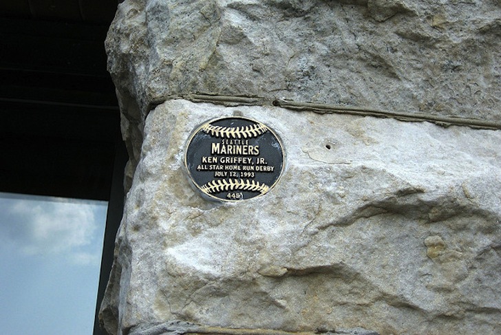 metal baseball honoring player in stone work of side of building