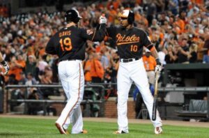 two baseball players locking arms on field