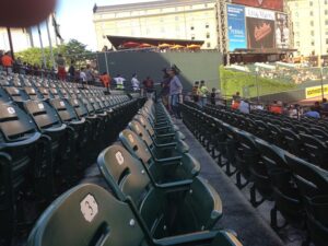 rows of empty seats at camden yards with people sitting in seats off in distance