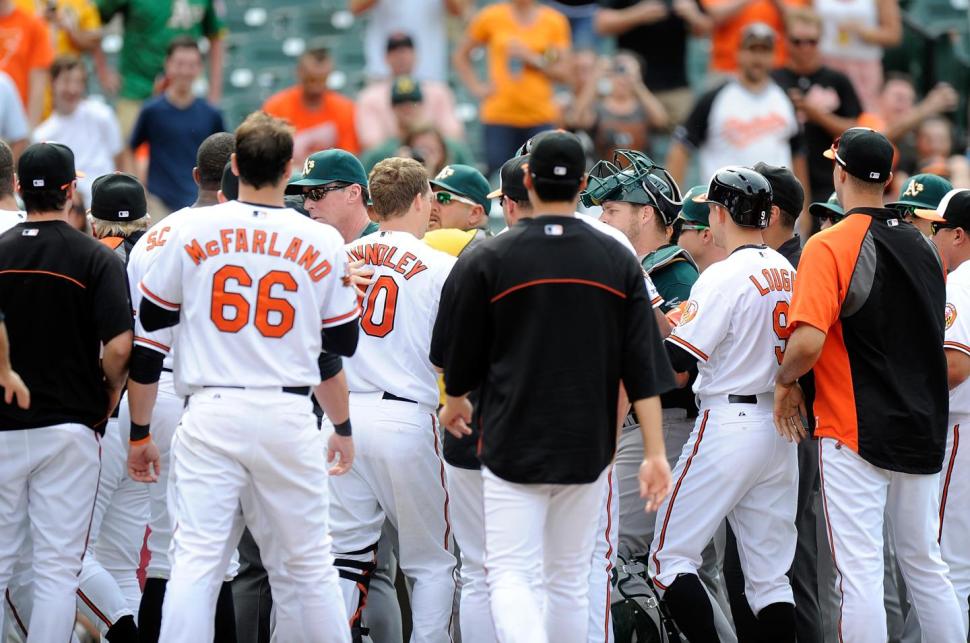 huddle of orioles players and oakland a's