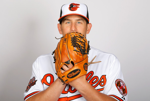 headshot of orioles oday holding glove up to face covering mouth